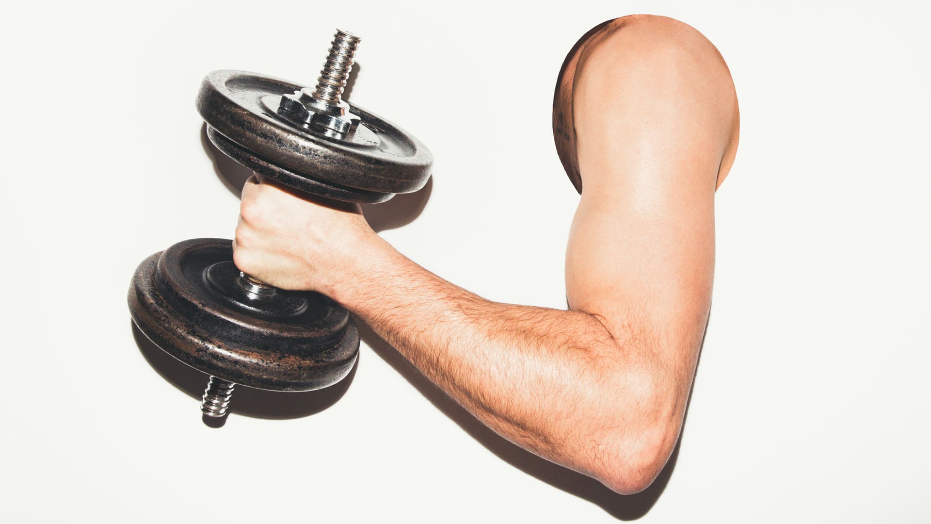 man sticking his bicep through whole with a dumbbell concept for ideal body type