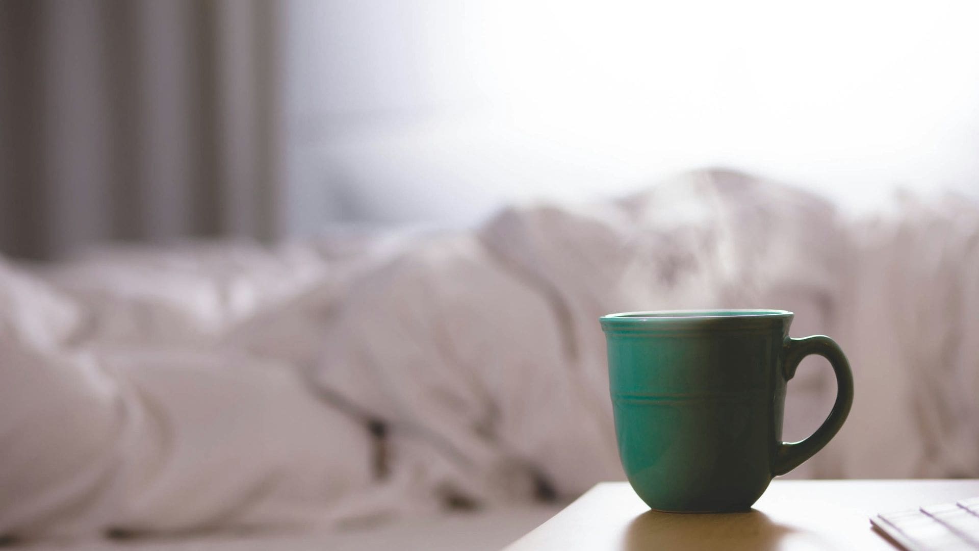 better sleep MAIN coffee cup sitting on bedside table next to unmade bed